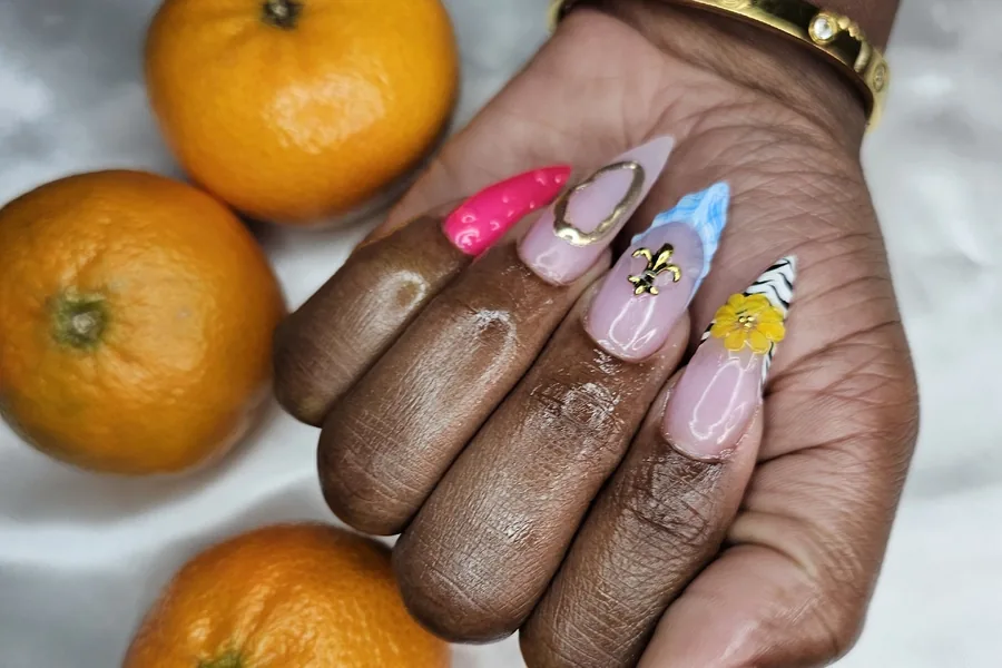 Summer nail set with citrus art, styled with oranges